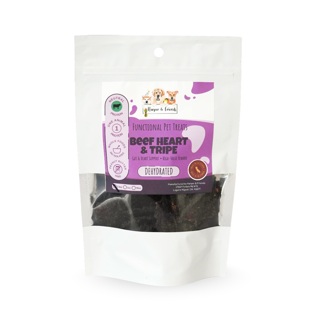 A stand-up pouch of dog treats on a plain white background. The package is mostly white with a large purple front label reading 'Functional Pet Treats Beef Heart & Tripe' and shows dark brown treat pieces visible through the clear lower section.