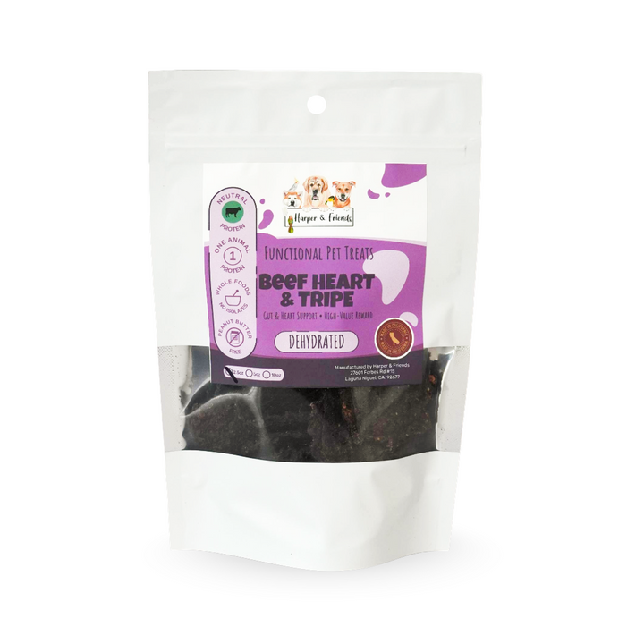 A stand-up pouch of dog treats on a plain white background. The package is mostly white with a large purple front label reading &