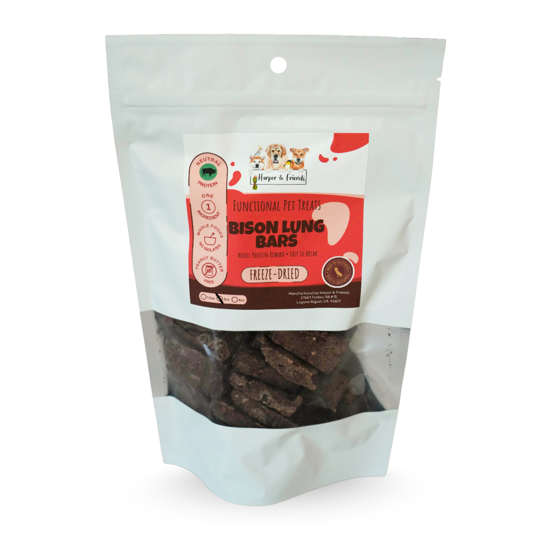 A stand-up pouch of freeze-dried pet treats on a white background. The package is white with a clear window showing dark brown rectangular bars inside.