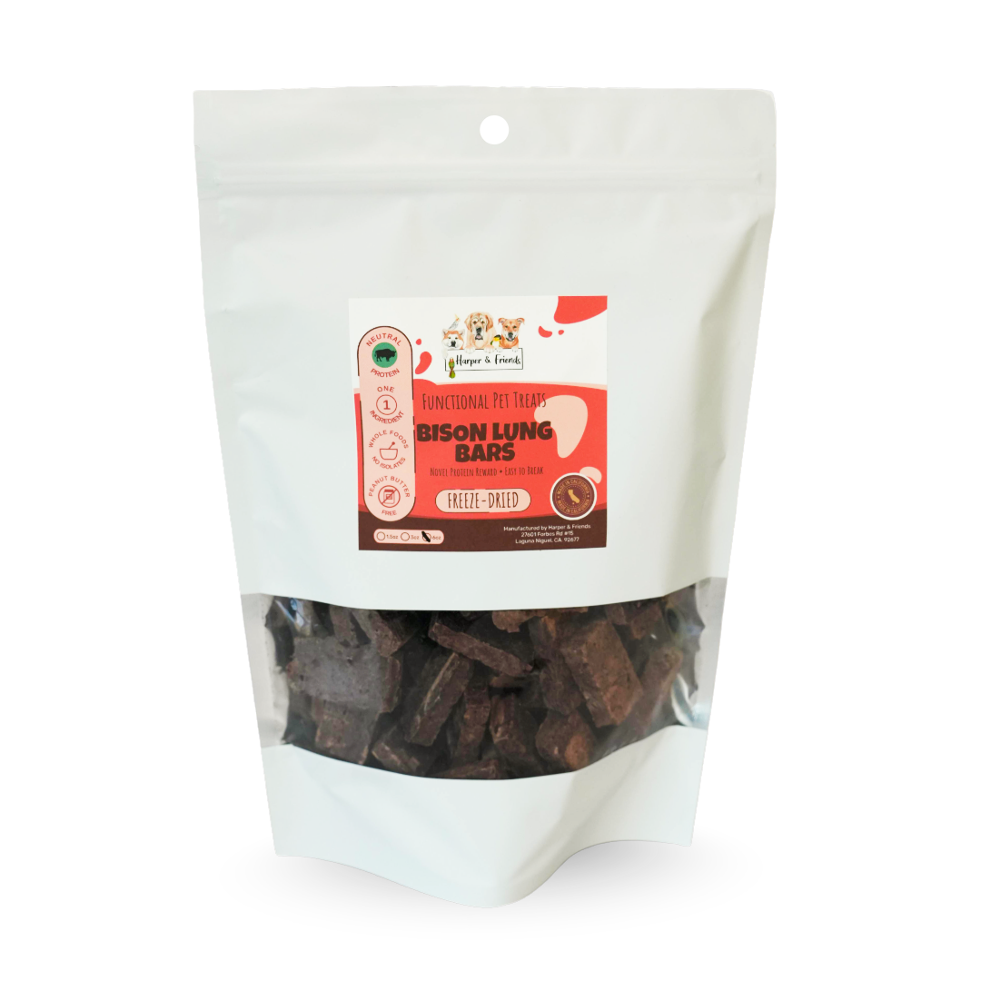 A stand-up pouch of dog treats on a white background. The package is white with a clear window showing dark brown rectangular treats inside.