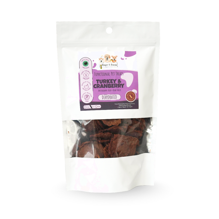 A stand-up pouch of dog treats on a white background. The package is white with a clear window showing brown treat pieces inside.